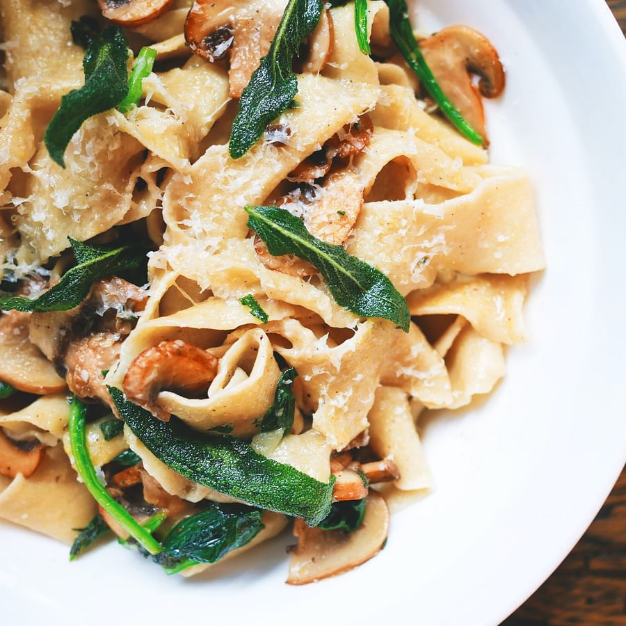 Assortment of essential ingredients for no-cook camping meals including bread, canned goods, fresh fruits, vegetables, nuts, seeds, and dried fruits