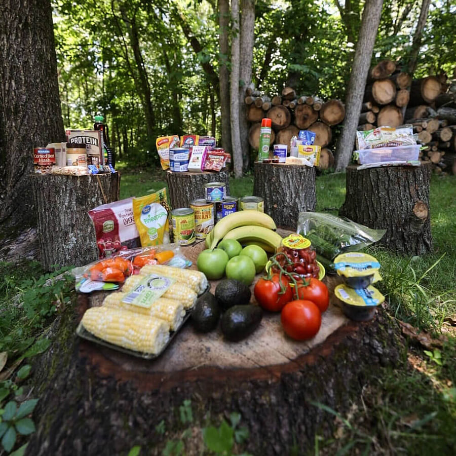 Assortment of typical camping foods including crackers, rice cakes, vegetable broth cubes, and spices