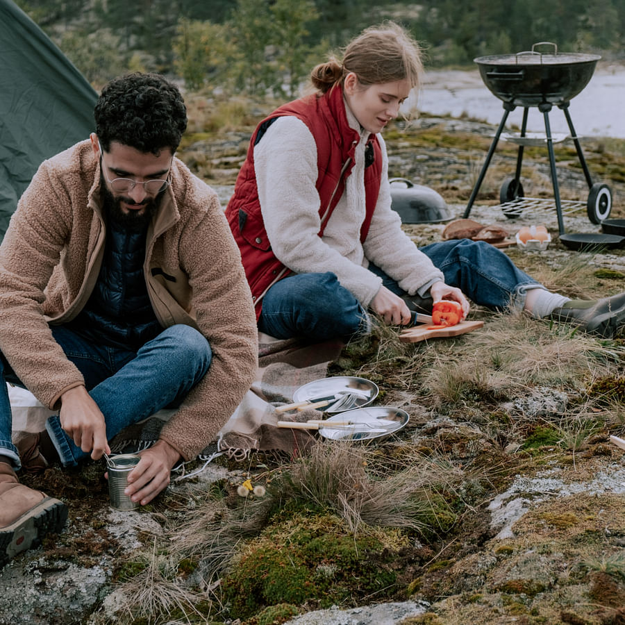 Campers enjoying pre-prepared meals in a scenic outdoor setting